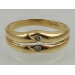 A 14 carat yellow gold double band ring, set with two round cut diamonds.