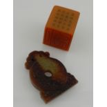 A Chinese soapstone seal, of square form, together with a Chinese russet jade carving. (2)