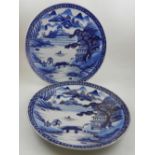 A pair of early 20th century Chinese blue and white porcelain chargers, decorated with a pagoda by a