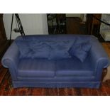 A Contemporary two-seater sofa bed, upholstered in a blue fabric.