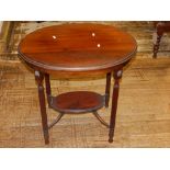 A 20th century oval mahogany two-tier occasional table, raised on gun barrel legs and joined by