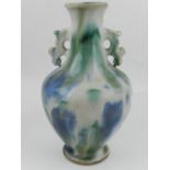 A Qajar twin handled ceramics vase, drip glazed with blue and green on cream ground. H.26cm