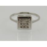 A 9 carat white gold and diamond ring, the square mount set with nine small diamonds.