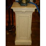 A painted and distressed pedestal cupboard, relief carved, raised on a square stepped base. H.95cm