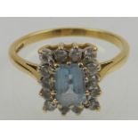 An 18 carat yellow gold, diamond, and aquamarine cluster ring.