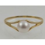 A 9 carat yellow gold and pearl set ring.