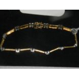 An 18 carat yellow and white gold articulated bracelet, the white gold segments set with round cut