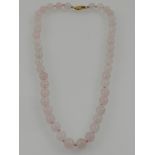 A faceted rose quartz beaded necklace, with a 14 carat yellow gold clasp.