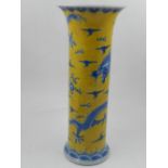 A Chinese yellow ground trumpet vase, decorated in blue with dragons chasing flaming pearls