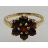 A 9 carat yellow gold and garnet floral cluster ring.