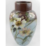 A large hand-painted porcelain vase, decorated with flowers on a blue and chocolate brown ground.