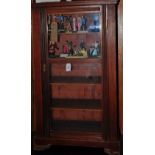 A mahogany cabinet with single glazed door, wooden shelves,