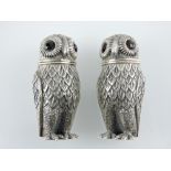 A pair of silver owl condiments with glass eyes