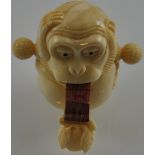 A carved bone tape measure modelled as a monkey with fruit