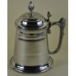 A George III style tankard with hinged lid with pineapple finial & scroll lion decorated handle,