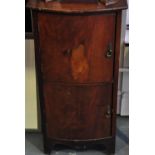 A mahogany bow fronted bedside table with twin cupboards,