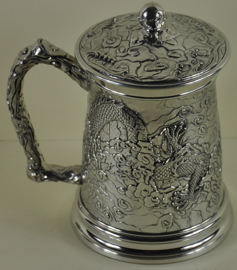 A Chinese design pint tankard with decoration forming a dragon & the lid having a flaming pearl