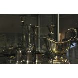 A silver plated sauceboat, a pair of plated table candlesticks, an oval nut dish,