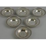 A set of six silver dishes with chased rims, marked 800,