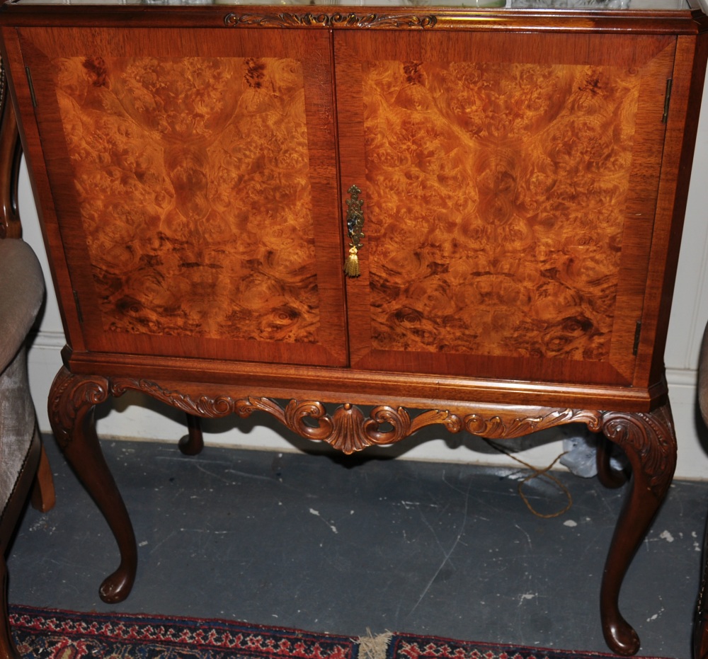 A walnut cocktail cabinet with double doors, mirrored and lit interior with original tray,