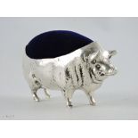 A large white metal pig pin cushion with blue velvet lining