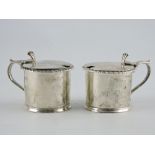 A pair of Victorian silver mustard drum pots with gadrooned borders and detatchable blue glass