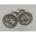 A pair of silver and cubic zirconia circular cluster ear studs.