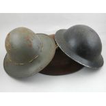 A WWII civilian helmet, marked 'prt SP' together with two other helmets,
