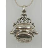 An unusual silver triple locket pendant in the form of a fob seal, suspended on a silver chain.