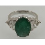 An 18 carat white gold, diamond, and emerald ring, the oval cut emerald 0f 4.