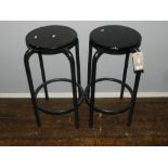 A pair of black painted steel framed stools, having round seats.