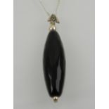 A silver and onyx pendant, suspended on a silver chain.