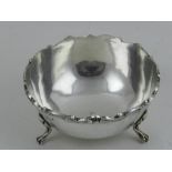 A white metal sugar bowl, raised on three paw feet, hallmarked 900,