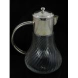 A white metal topped glass lemonde jug, the body of wrythen design,