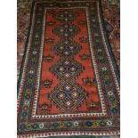 A red ground Qashqai runner, decorated with five pole medallion to centre, within floral borders,