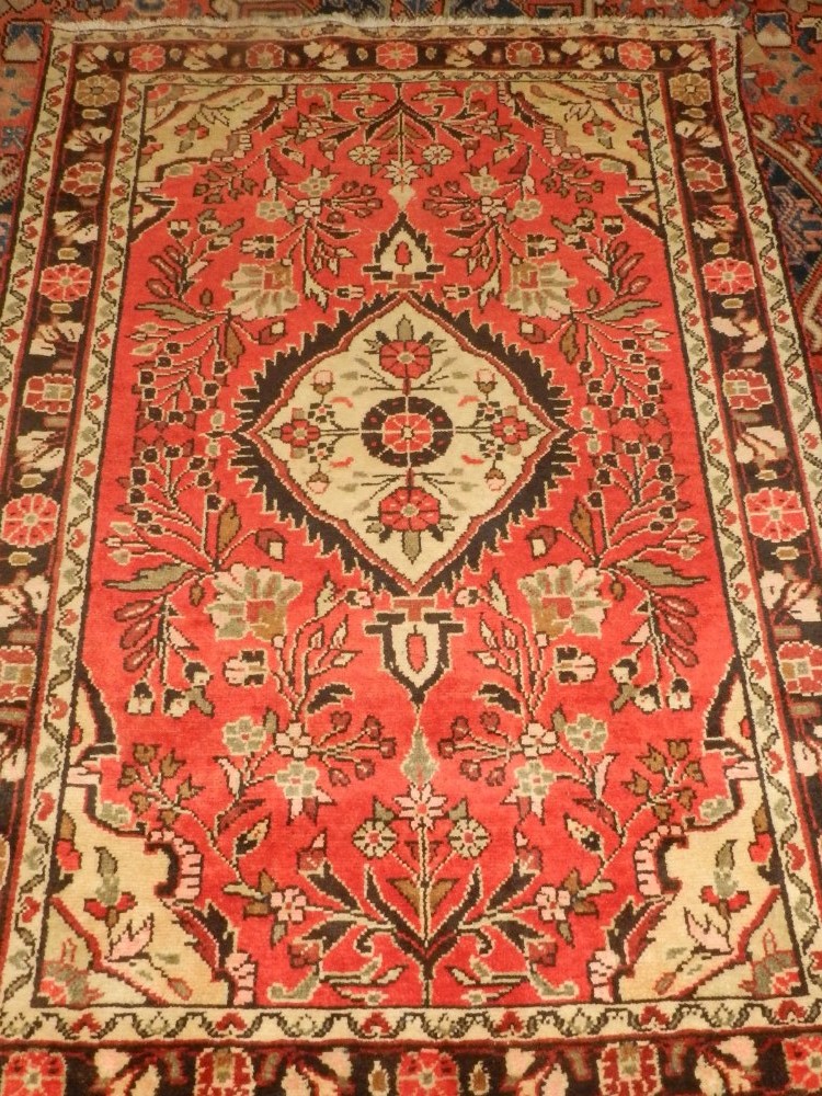 A pair of Persian red ground rugs, having cream teardrop medallion to centre on a floral ground, - Image 2 of 2