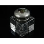 A silver plated glass desk inkwell, with star cut base, the lid with enamel image of a dog to top.