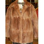 A ladies brown rabbit short fur coat, with silk lined interior and concealed hook fastenings.