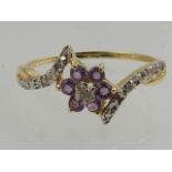 A 9 carat yellow gold, diamond, and amethyst floral crossover ring.