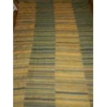 A patchwork wool kelim carpet, decorated with bands of yellow and green.