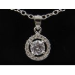 A silver and cubic zirconia halo shaped pendant necklace.