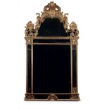 Grand miroir de cheminée à parecloses d'époque Régence en bois sculpté et doré de motifs Rocaille