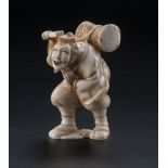 Okimono en ivoire figurant un bateleur Japon époque Meiji portant sur le dos un tambour de type