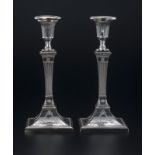 Paire de chandeliers de style George II en métal argenté. Le fût en forme de gaine cannelée et la