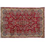 Tapis Kirman Iran 1ère moitié du XXe s. à champ rouge orné d'un grand bouquet de fleurs formant