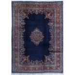 Tapis Sarough Iran milieu du XXe s. à médaillon central composé de fleurs sur fond bleu nuit bordure