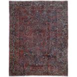 Tapis Sarough Iran milieu du XXe s. à décor de bouquets de fleurs sur fond rouge bordure bleu nuit