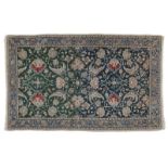 Tapis Naïn	 Iran	 en laine et soie	 à décor de rinceaux fleuris sur fond vert et bleu	 bordure bleue