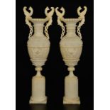 Paire de vases sur piédouche	 Italie	 XXes.	 en albâtre à panse ornée de frises de fleurs sculptées
