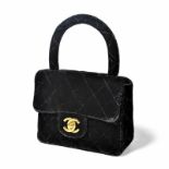 Chanel	 petit sac à rabat en velours noir matelassé	 poignée rigide en demi-cercle	 fermoir doré